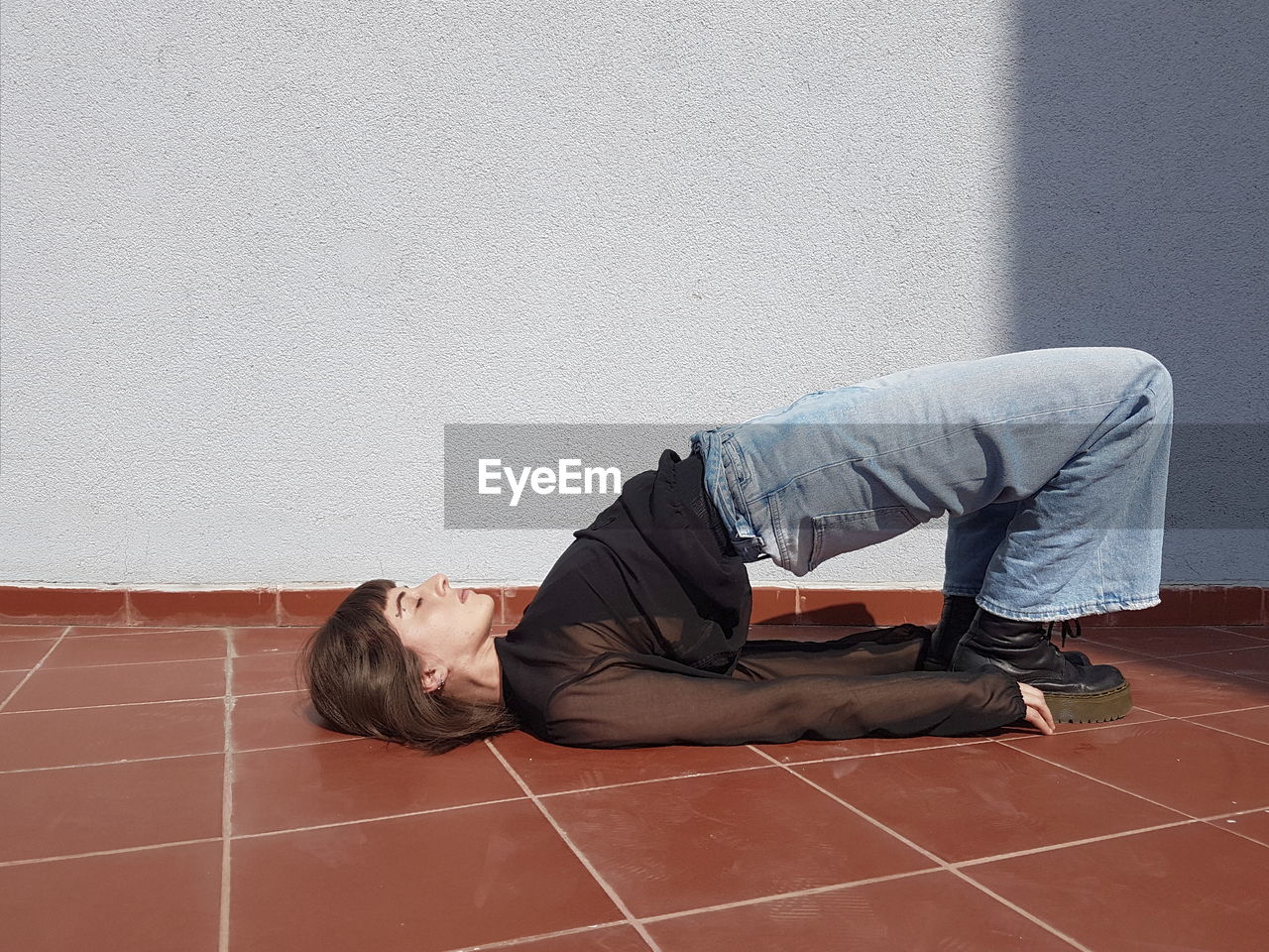 Woman stretching body against wall