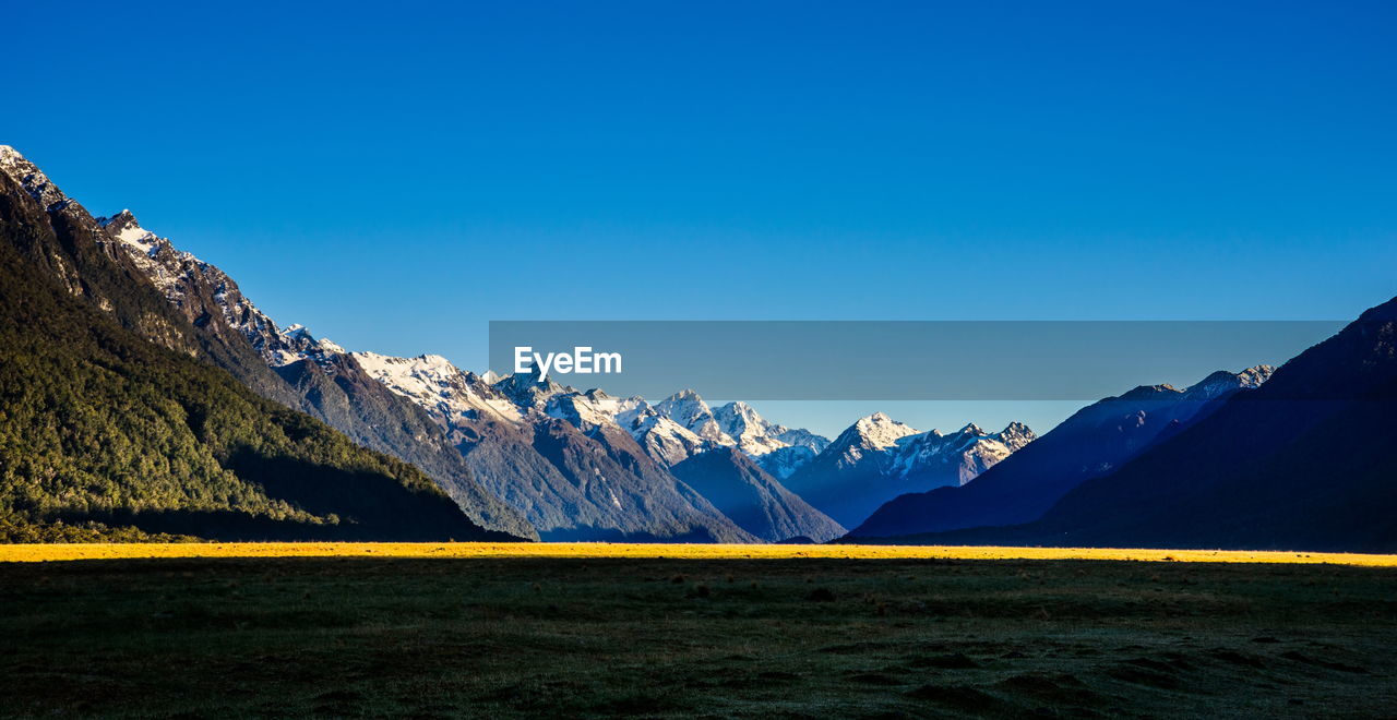 Scenic view of mountains against blue sky