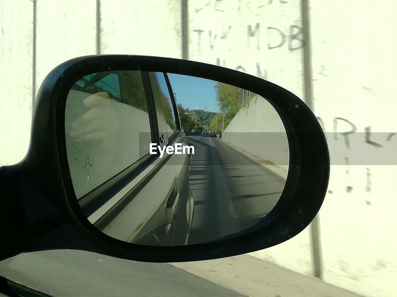 REFLECTION OF SIDE-VIEW MIRROR OF CAR ON WINDOW