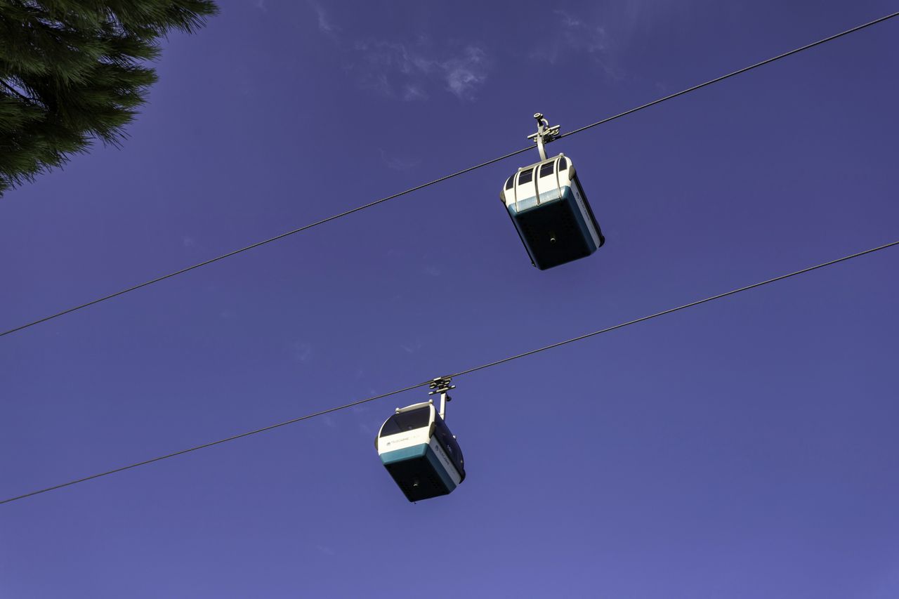 Low angle view of overhead cable car against sky