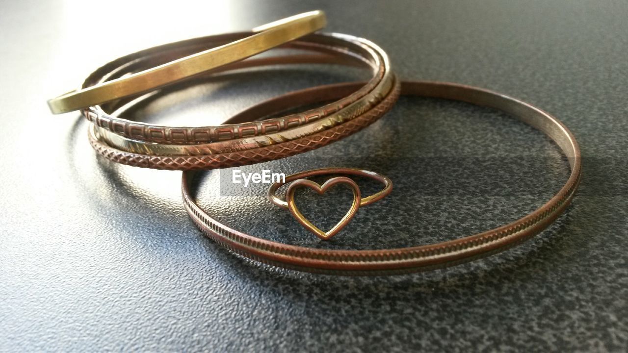 High angle view of bracelets with ring on table