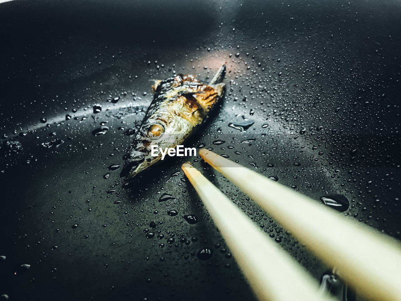 Close-up of fish with chopsticks in bowl