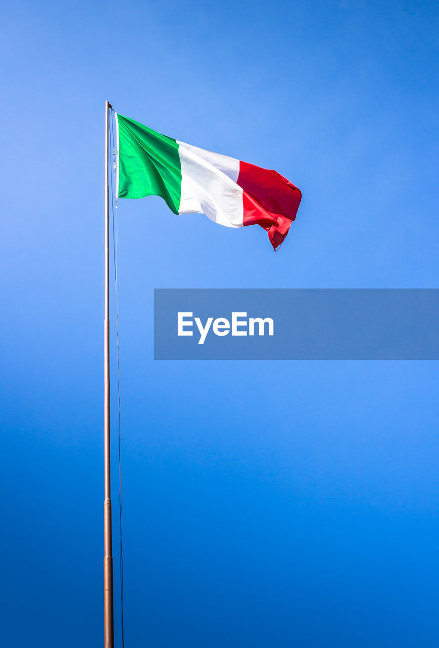 Low angle view of italian flag against blue sky during sunny day