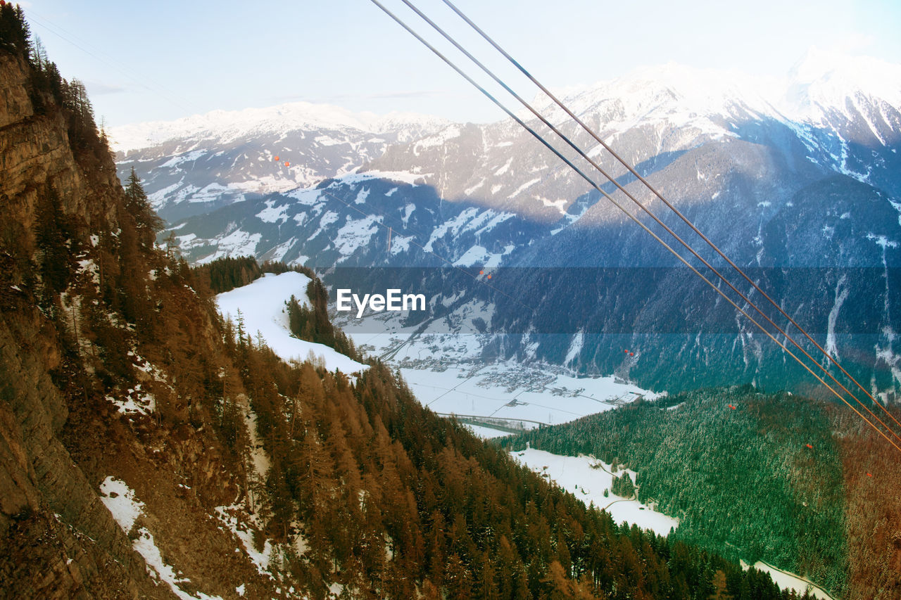 OVERHEAD CABLE CAR OVER SNOWCAPPED MOUNTAINS