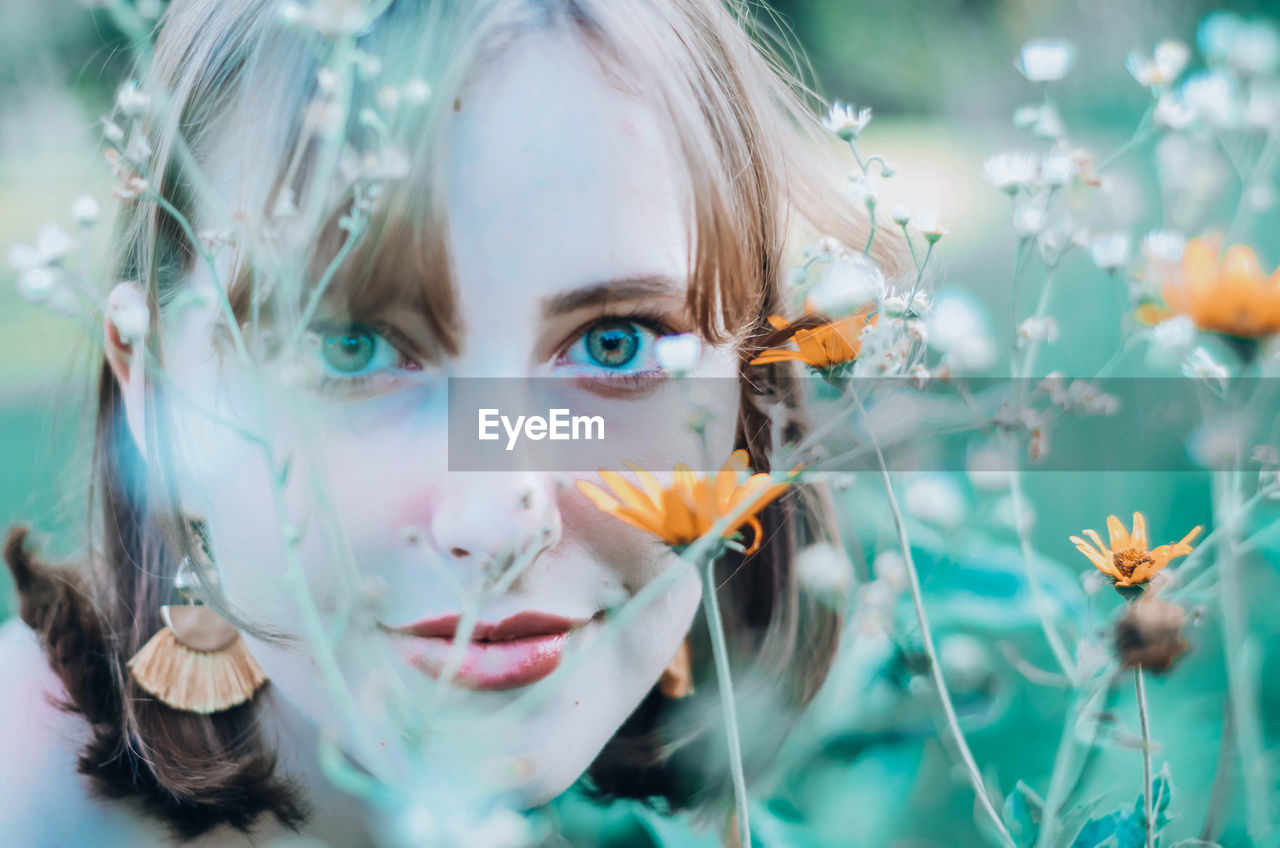 Close-up of beautiful woman looking through plants