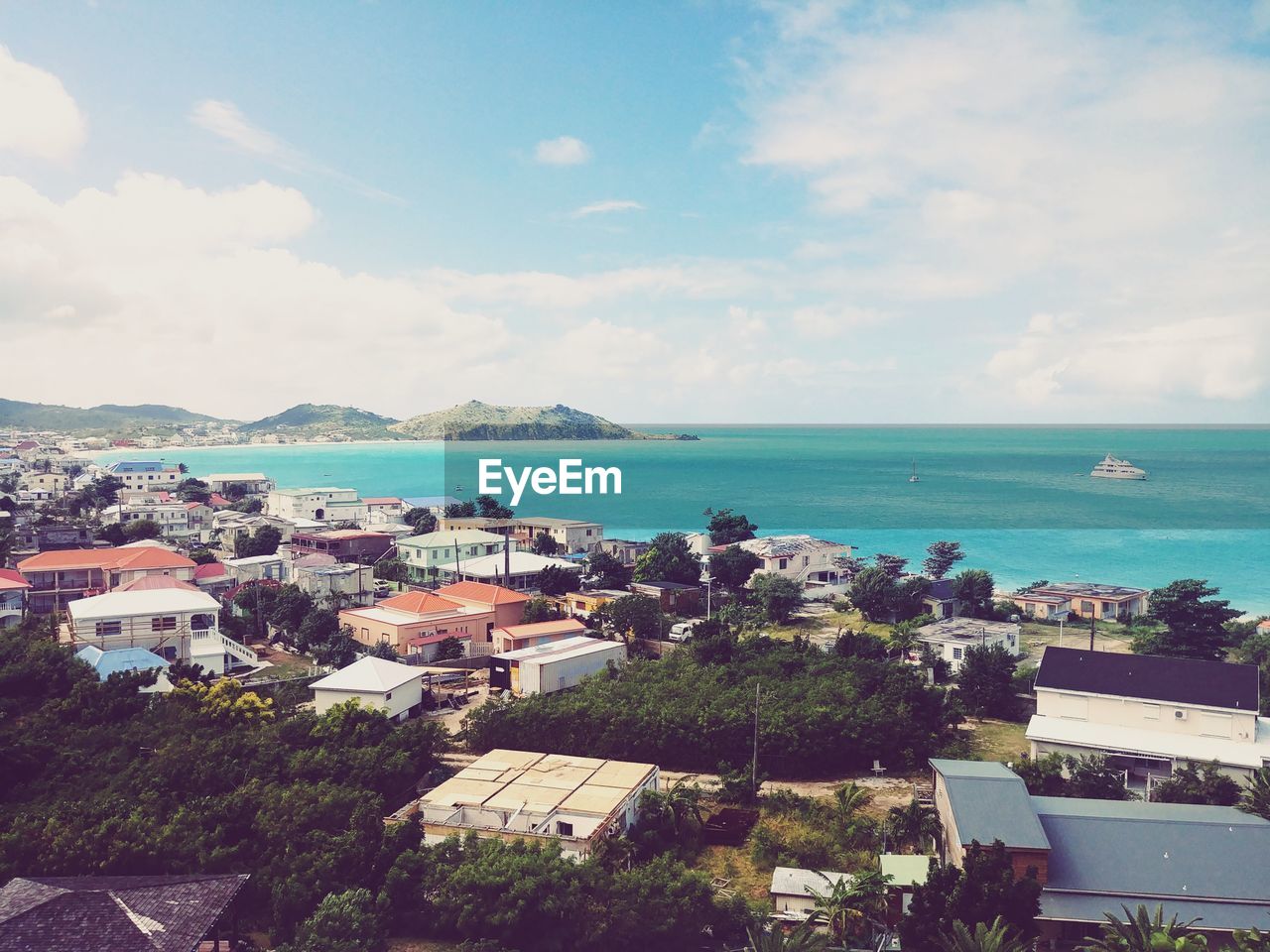 High angle view of townscape by sea against sky