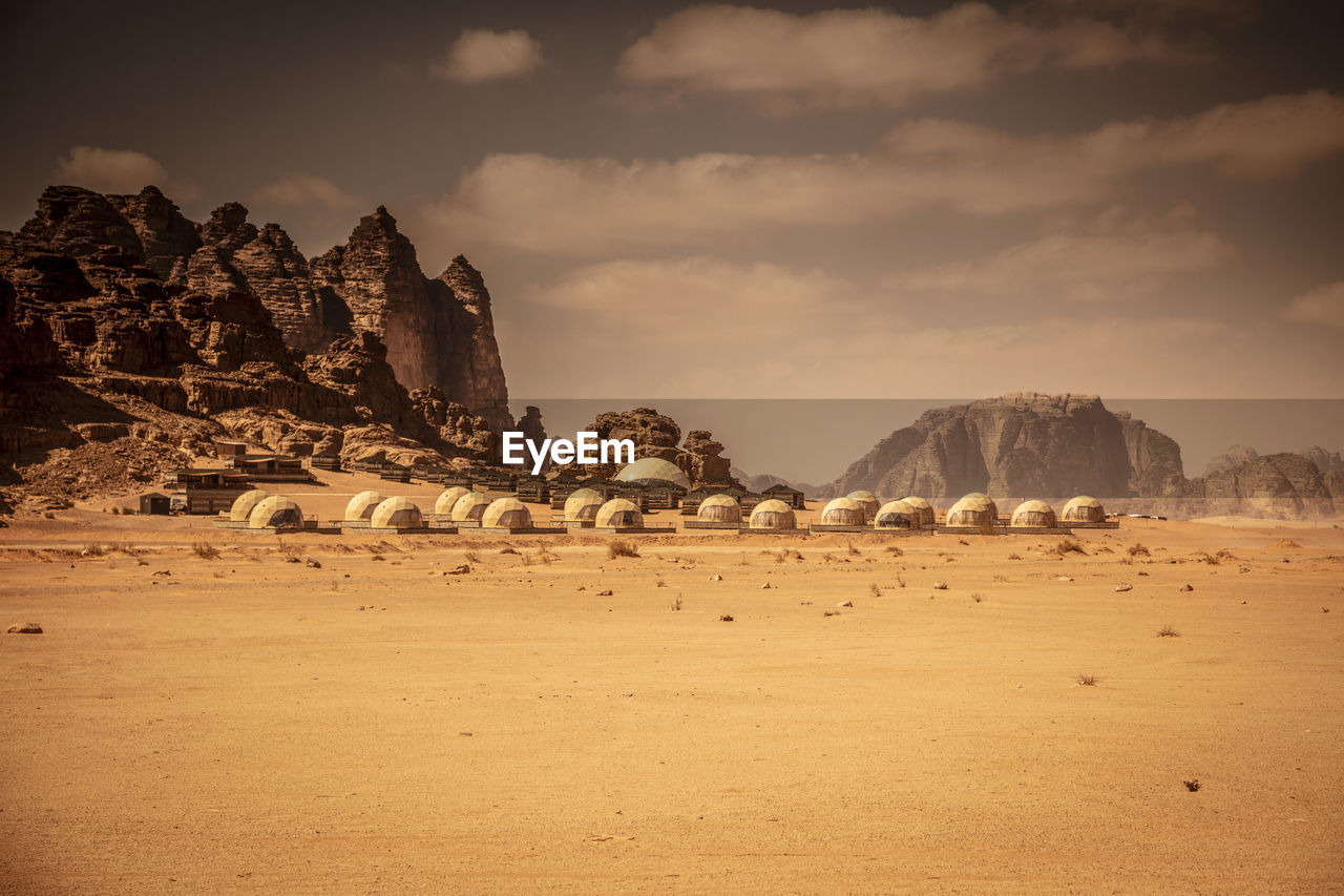 PANORAMIC VIEW OF ROCK FORMATIONS IN DESERT AGAINST SKY