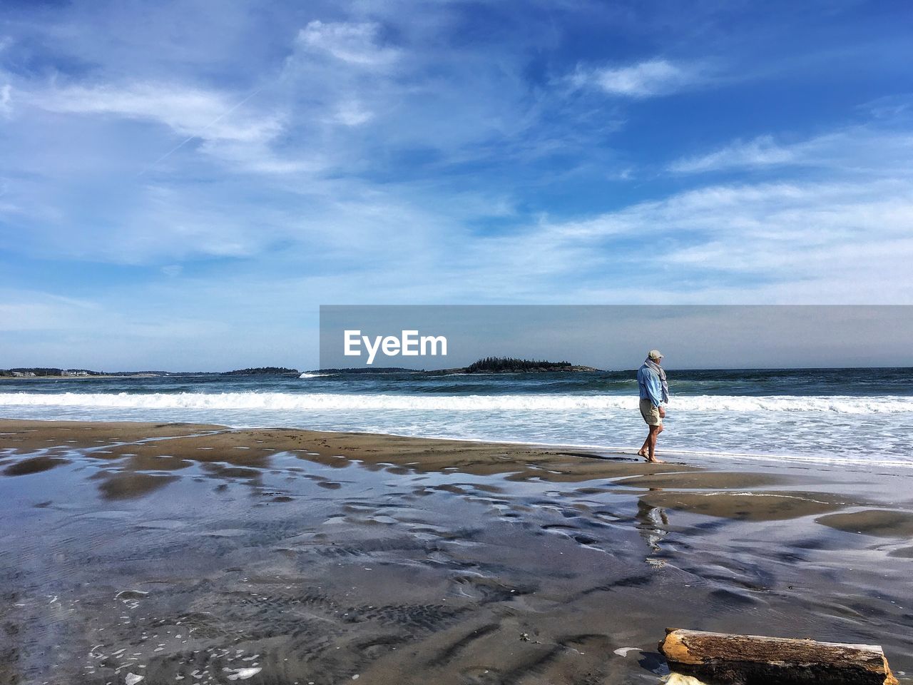 FULL LENGTH OF MAN STANDING AT BEACH AGAINST SKY