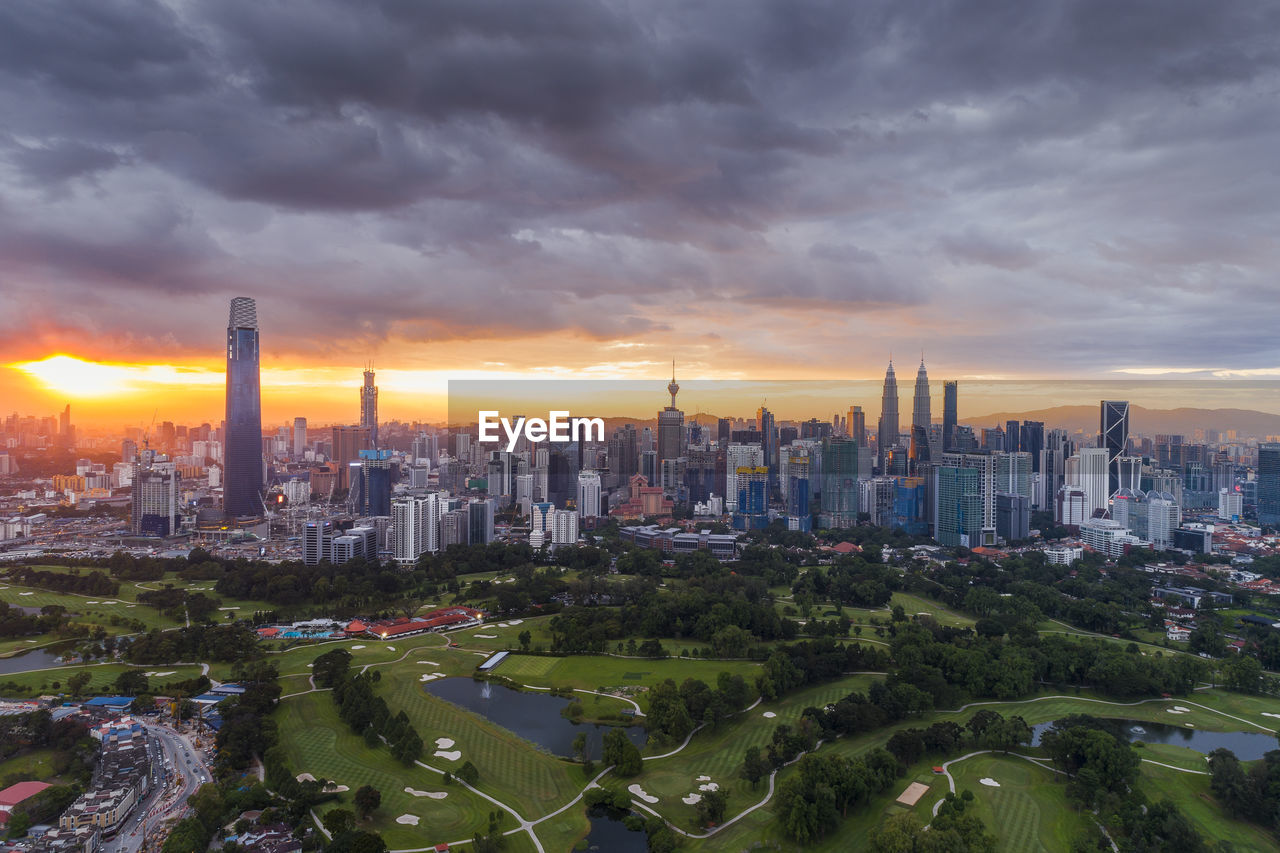 AERIAL VIEW OF BUILDINGS AGAINST CLOUDY SKY