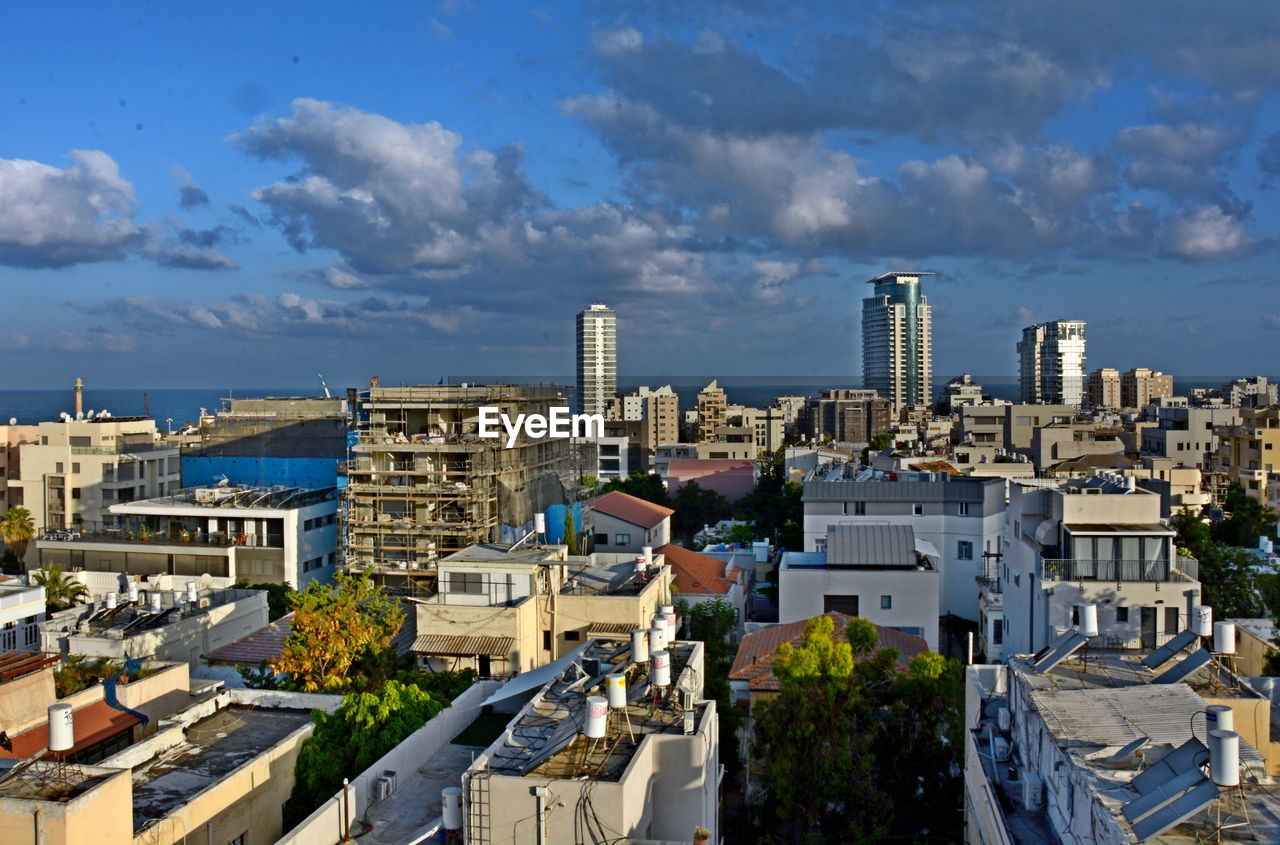 HIGH ANGLE VIEW OF BUILDINGS AGAINST BLUE SKY