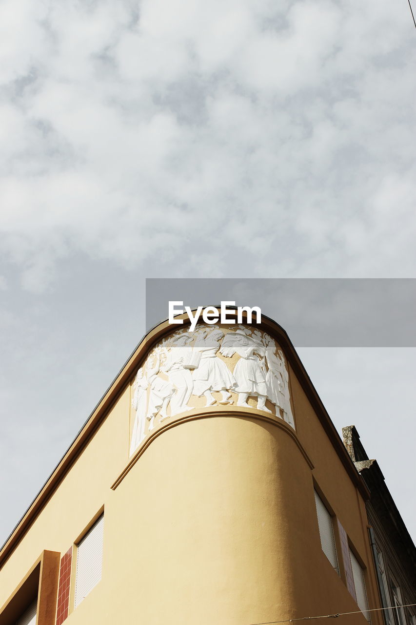 HIGH SECTION OF BUILDING AGAINST CLOUDY SKY