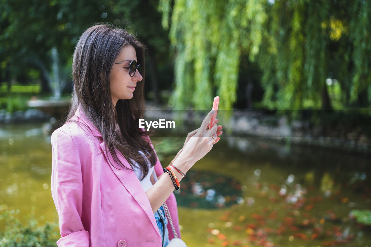 Midsection of woman standing on mobile phone