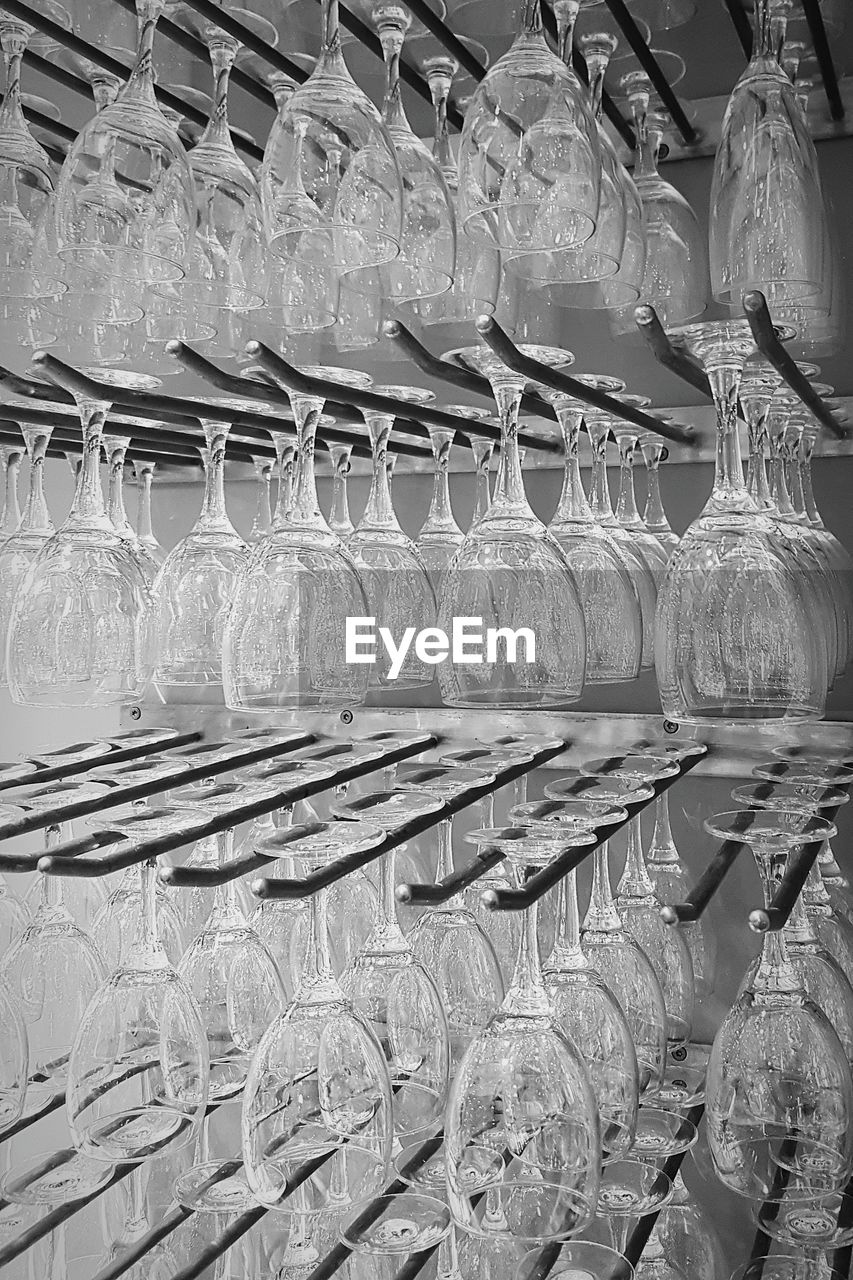 Full frame shot of wineglasses arranged on rack in store