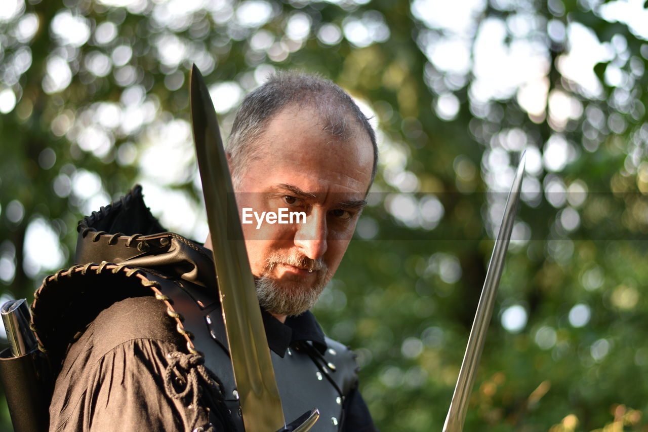 Portrait of man wearing knight costume against tree