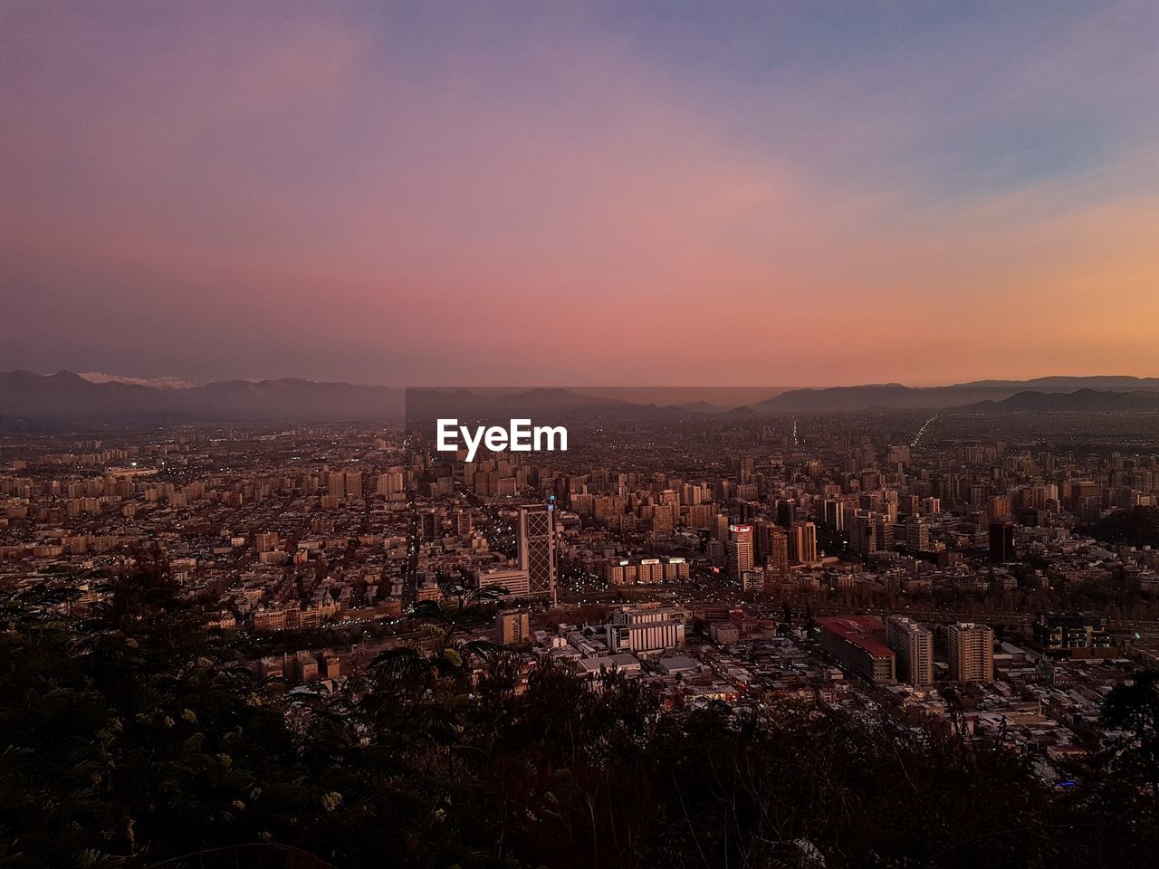 High angle view of illuminated cityscape against sky during sunset