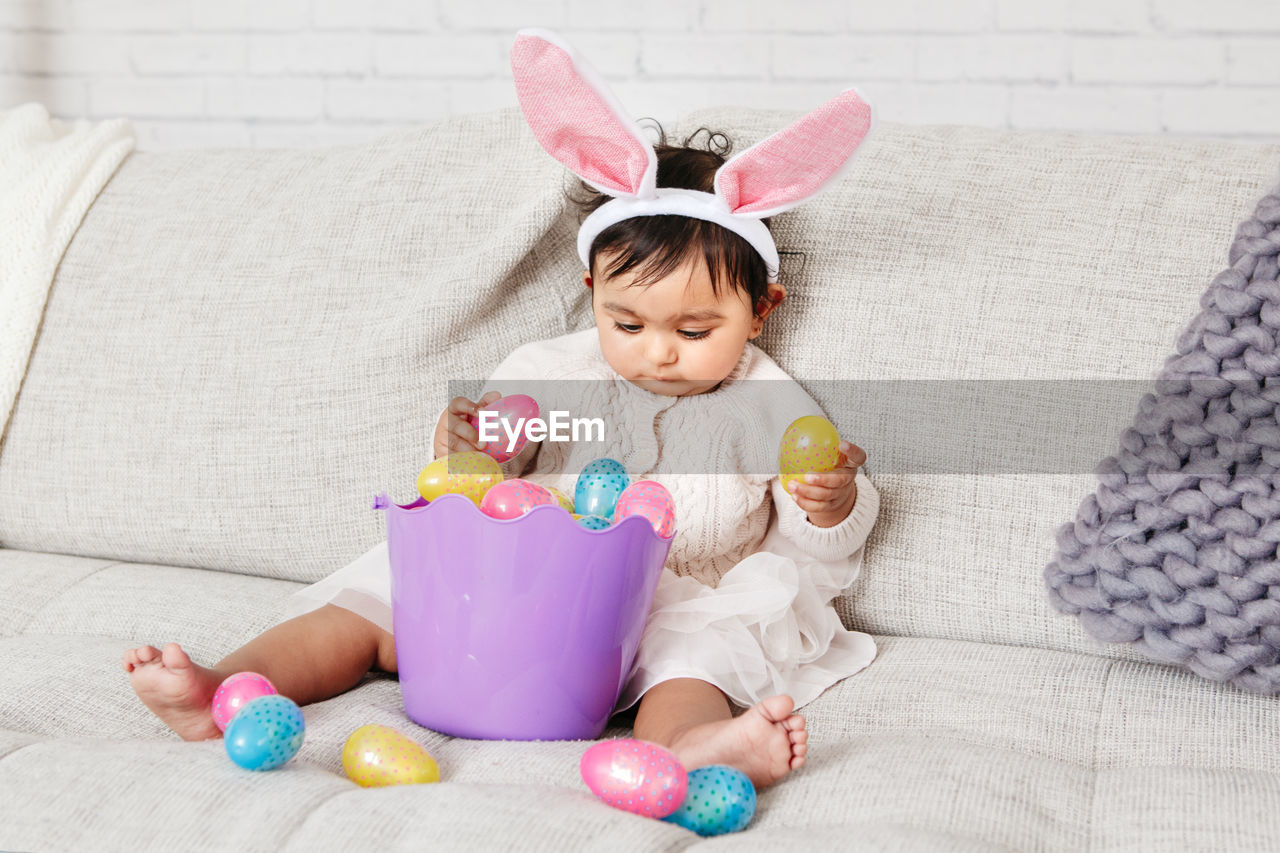 Cute girl wearing costume sitting on sofa