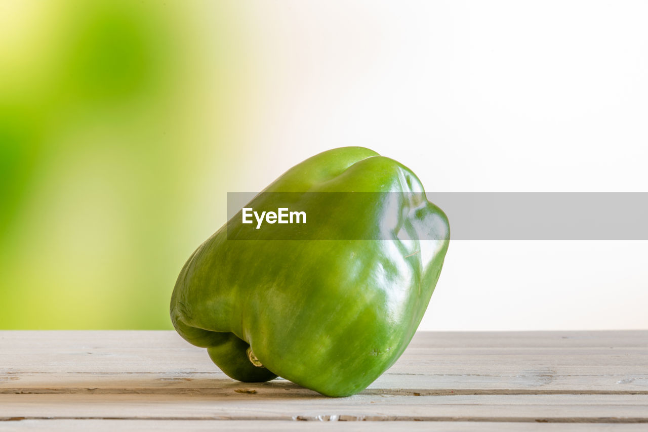 CLOSE-UP OF GREEN CHILI PEPPER ON TABLE