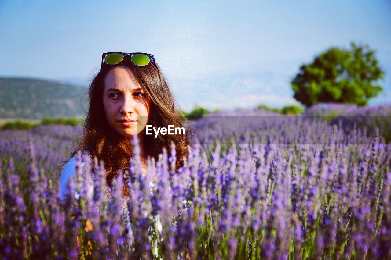 Close-up of woman looking away amidst lavender field