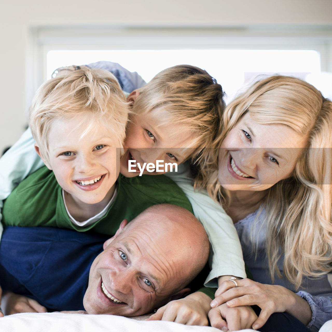 Portrait of happy family enjoying in bed