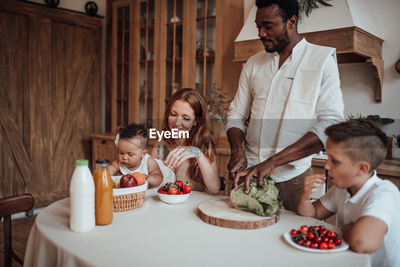 Father and daughter sitting on table