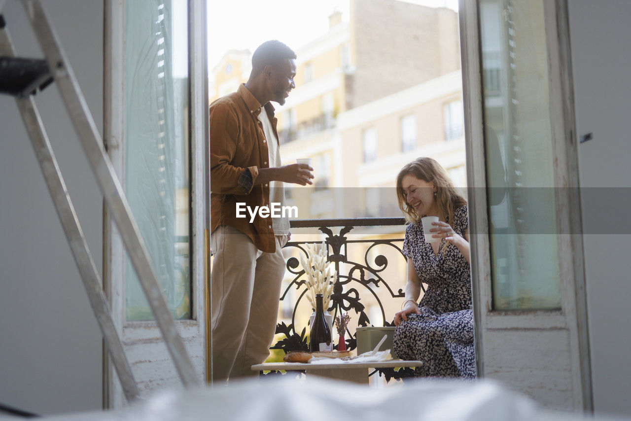 Smiling couple having lunch date in balcony