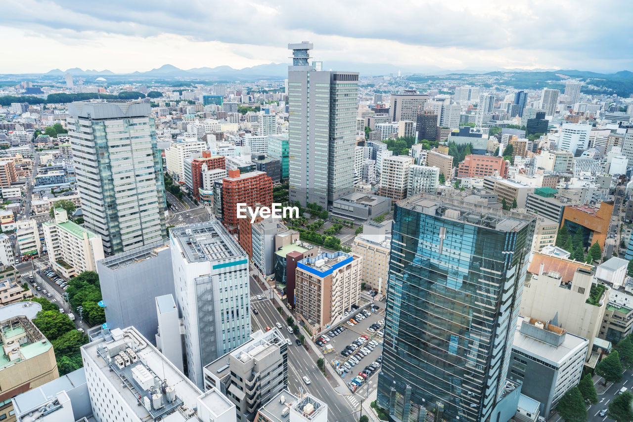 HIGH ANGLE VIEW OF BUILDINGS AGAINST SKY IN CITY