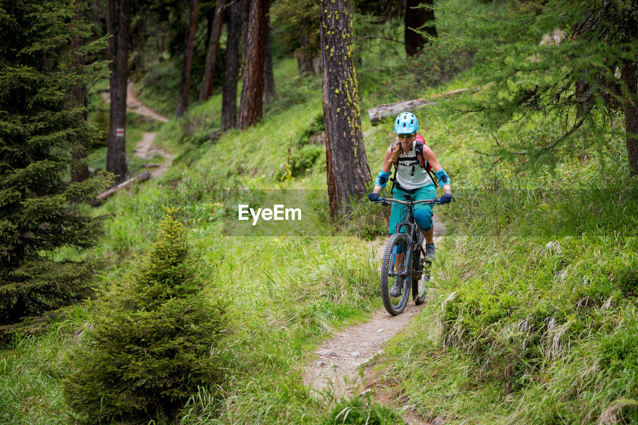 Woman riding bicycle at forest