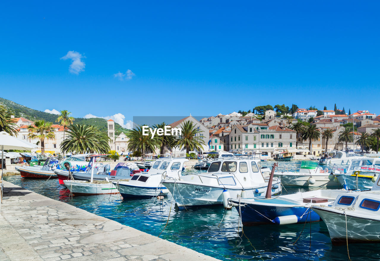 Boats moored on sea against blue sky