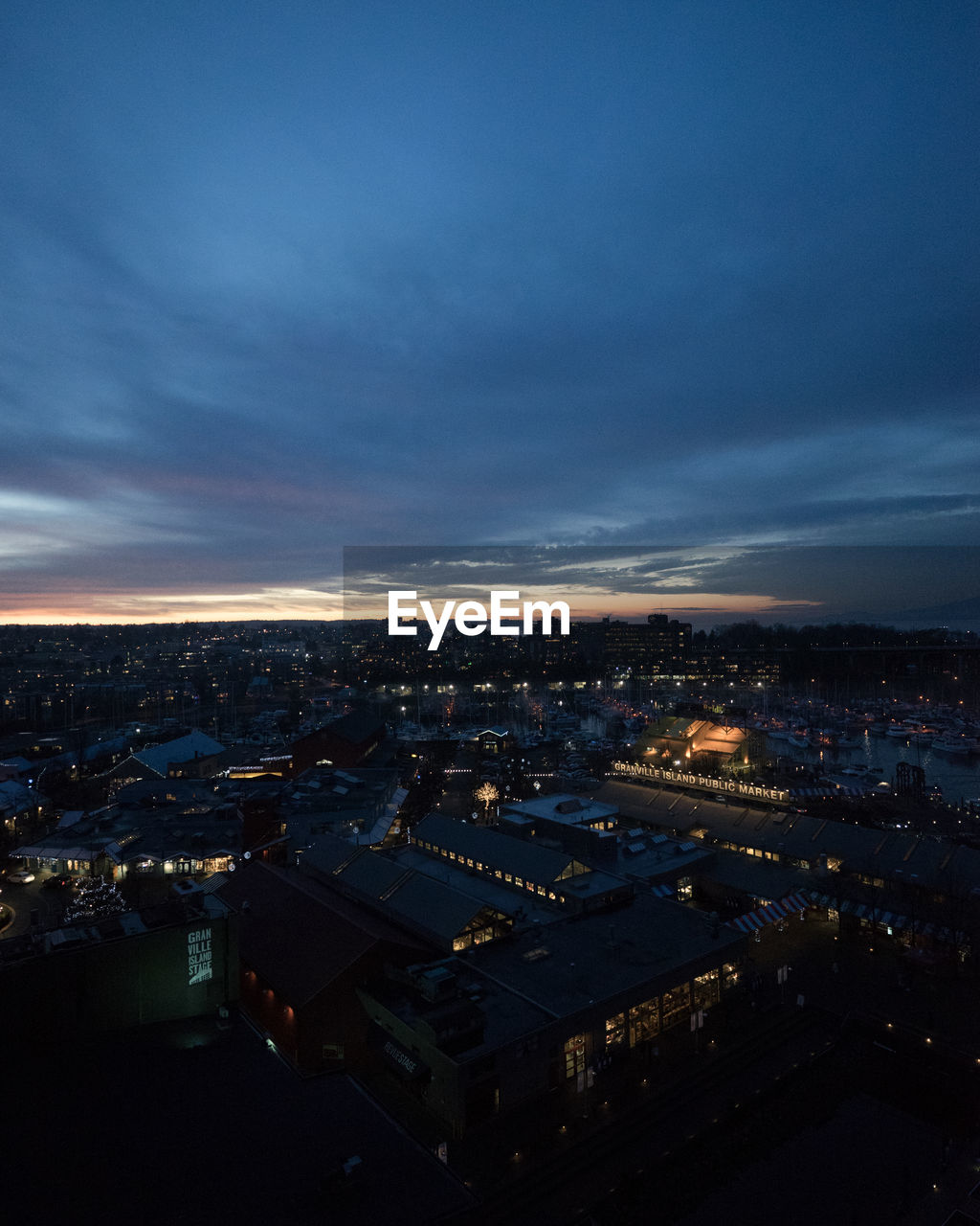 High angle view of illuminated city against sky at dusk