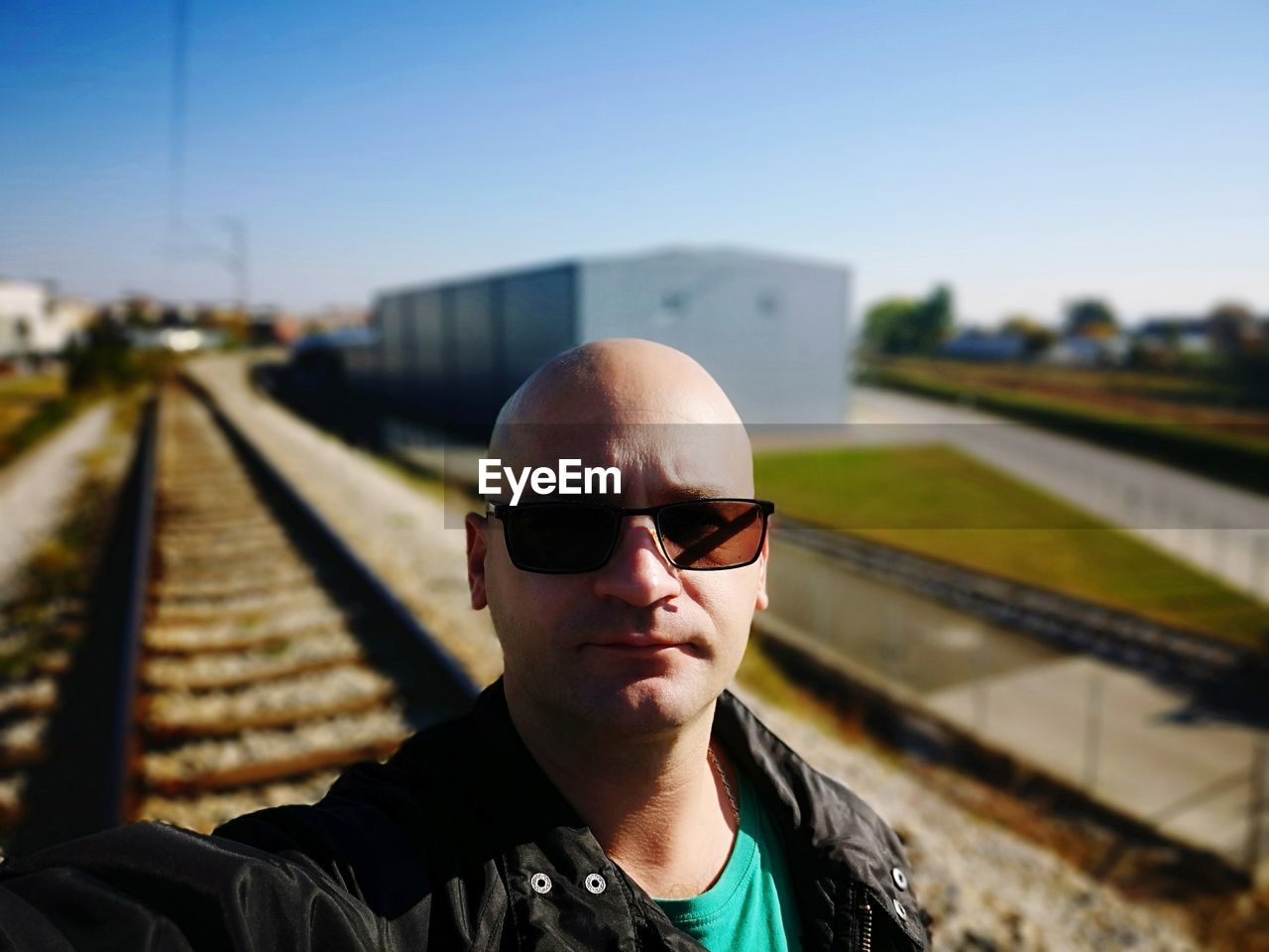 Portrait of man wearing sunglasses at railroad station