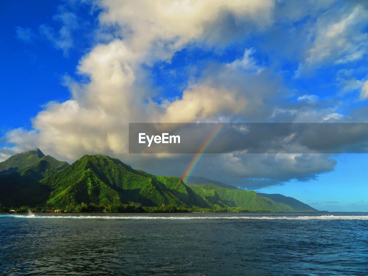 Scenic view of rainbow over sea against sky