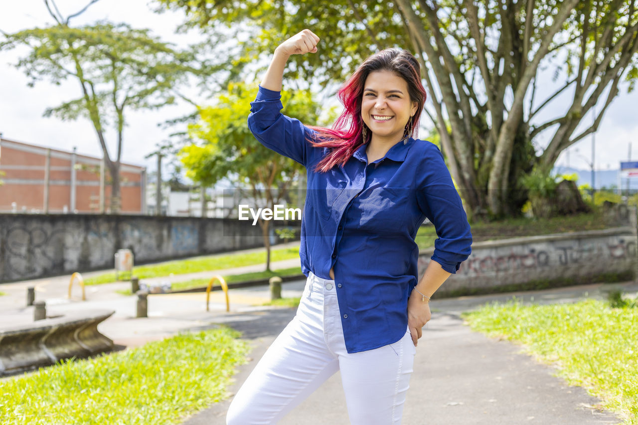 Stylish young woman showing her fist and strength