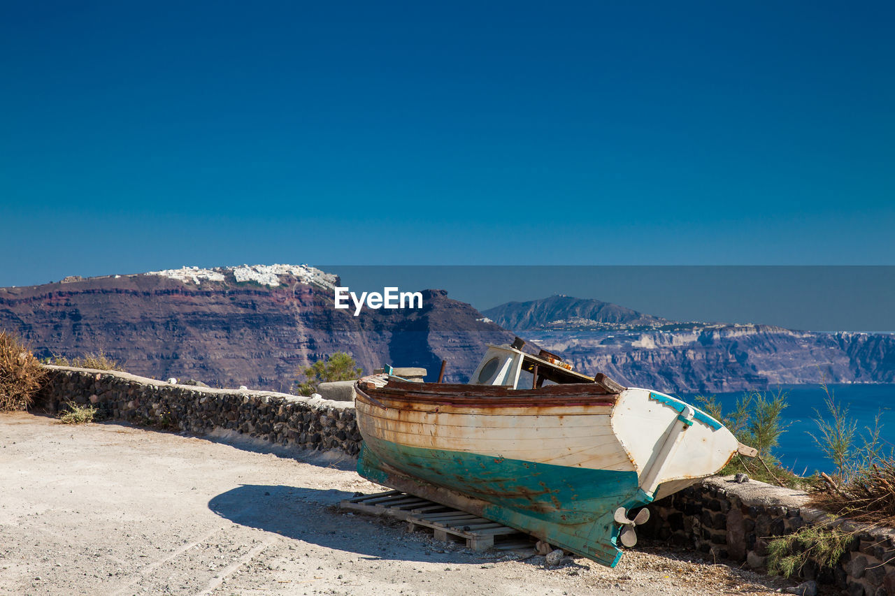 Old boat on the top of a cliff in santorini island in a beautiful early spring day