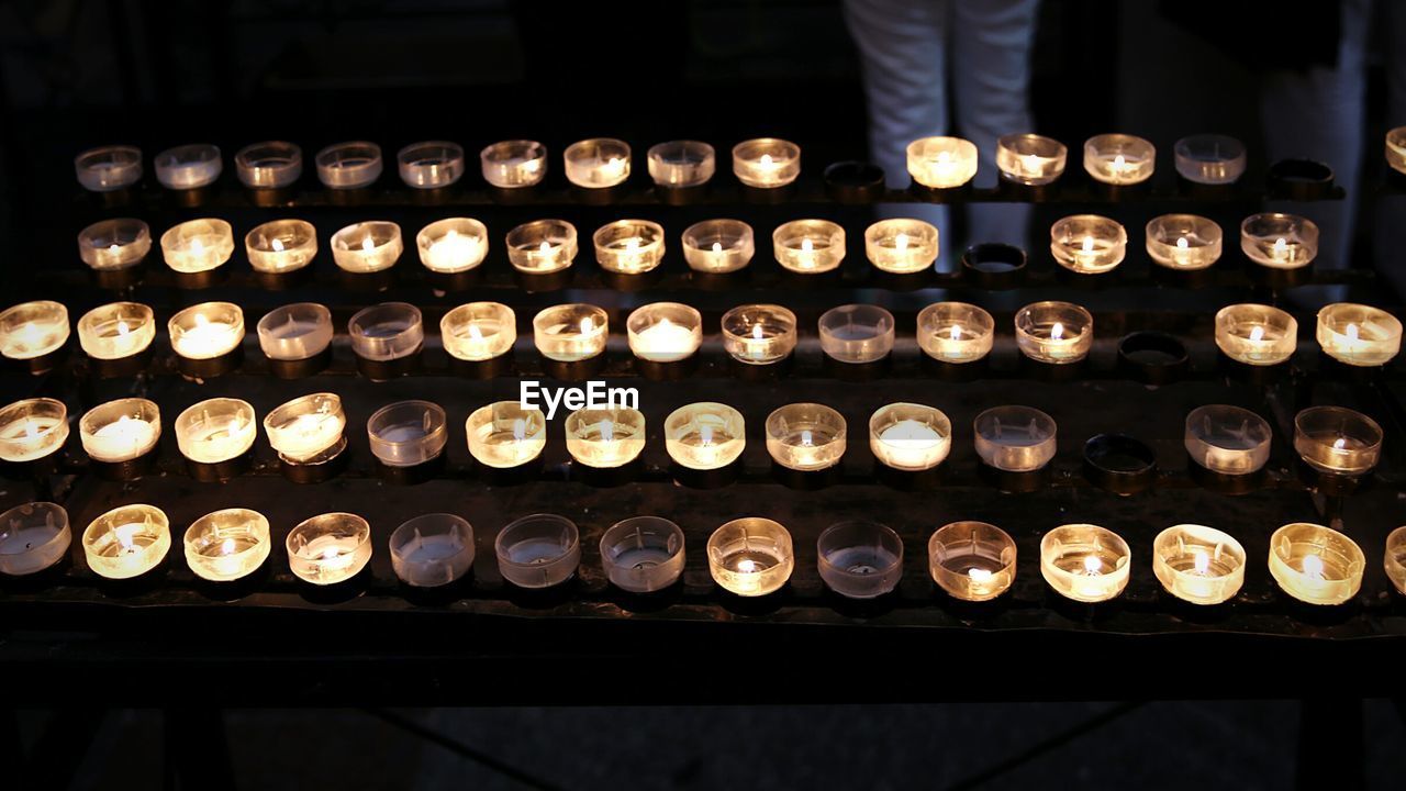 High angle view of burning tea light candles at cologne cathedral