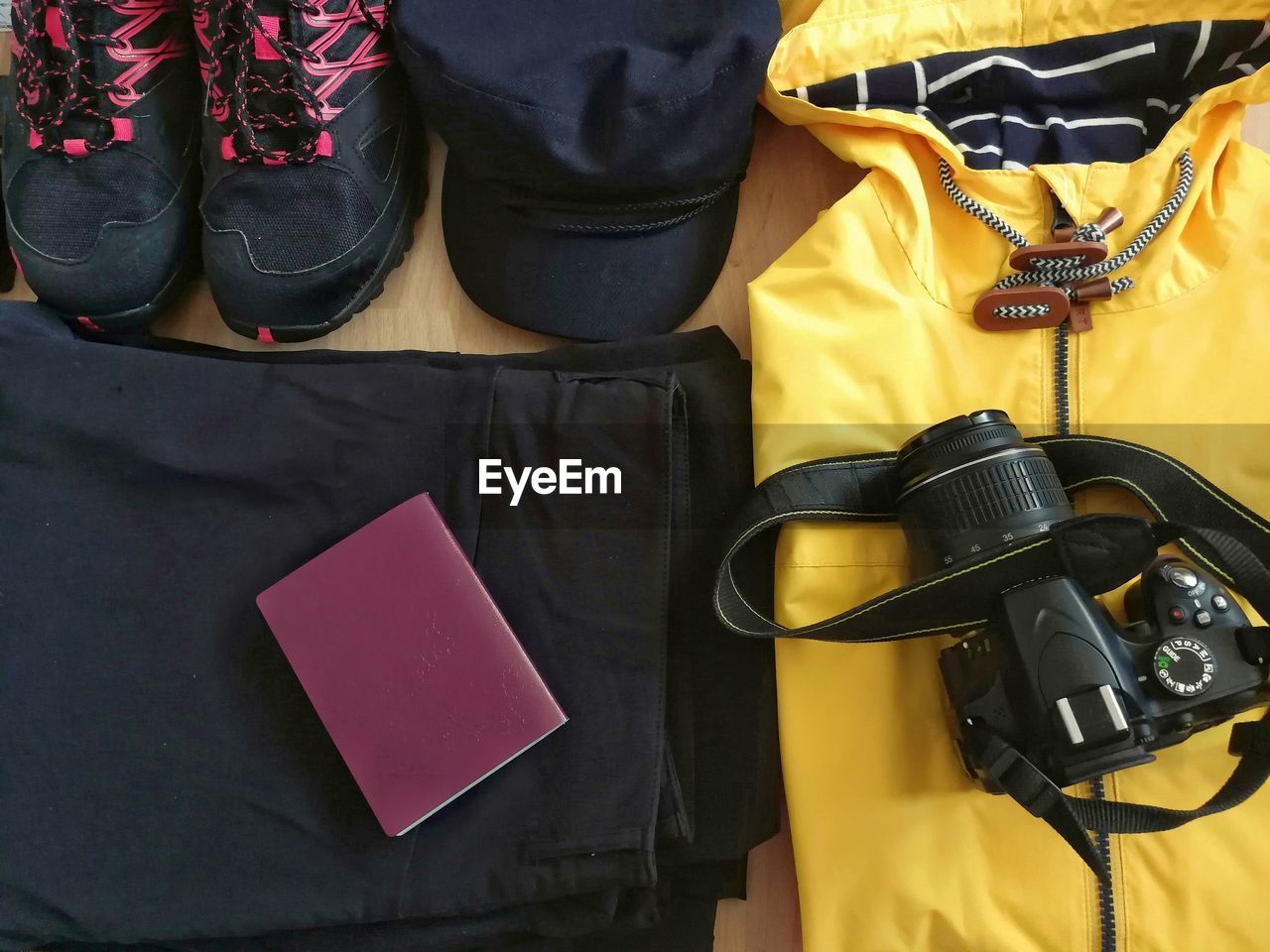 High angle view of camera with personal accessories and passport on table