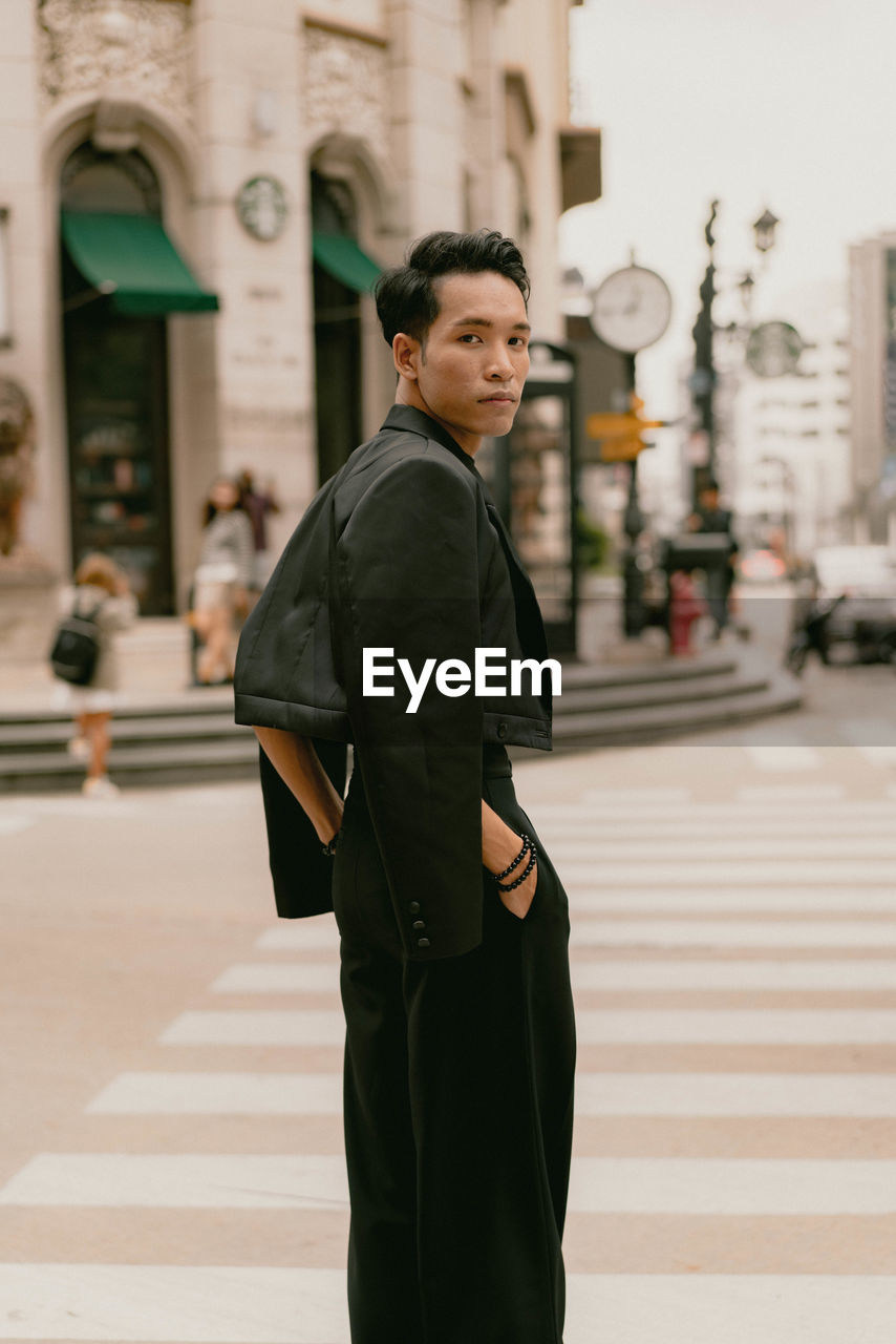 Portrait of young man standing in city