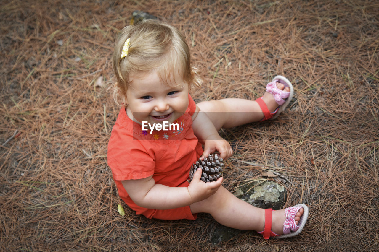 Little girl holding a cone in the woods forest