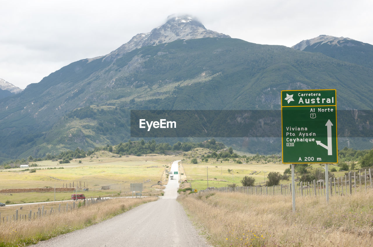 ROAD SIGN ON LANDSCAPE AGAINST SKY