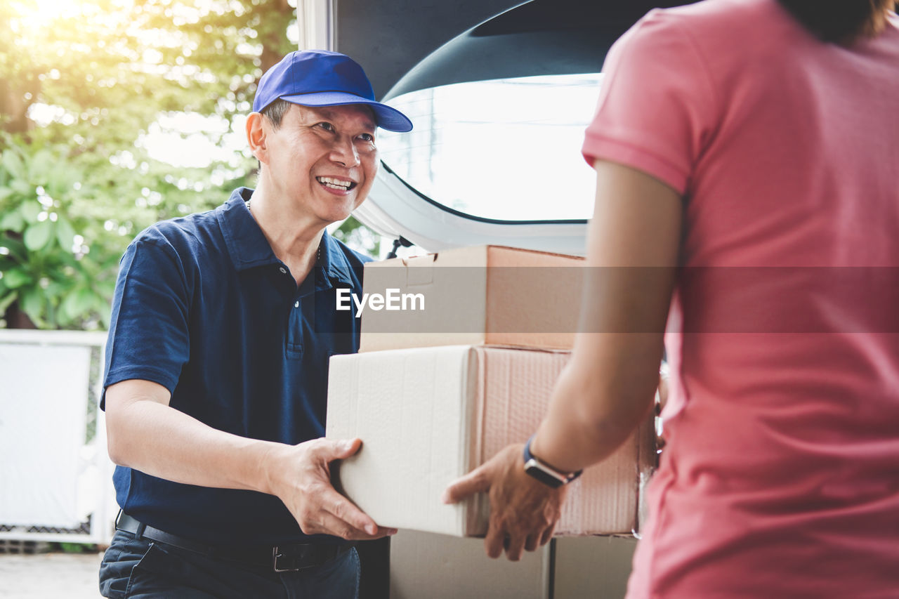 Smiling delivery man giving boxes to woman