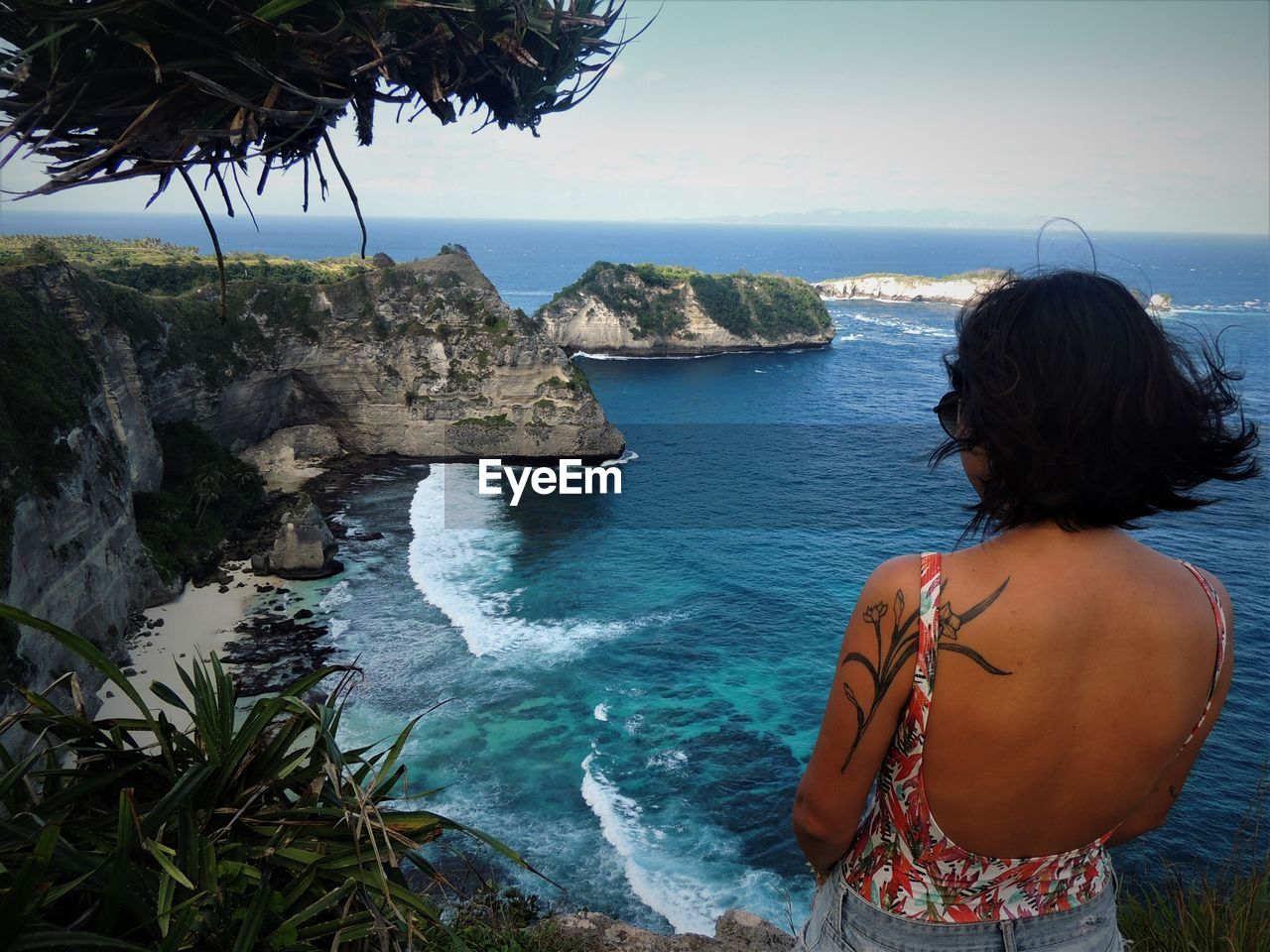 Rear view of woman standing against sea