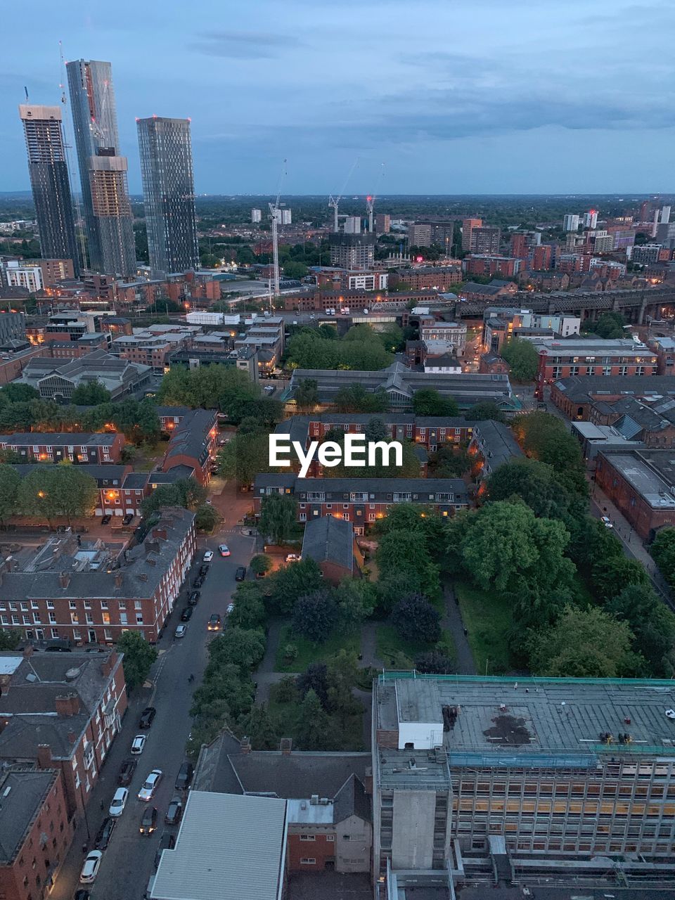 HIGH ANGLE VIEW OF BUILDINGS AND TREES AGAINST SKY