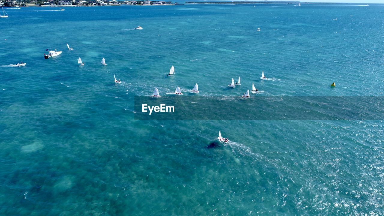 HIGH ANGLE VIEW OF BOATS IN SEA