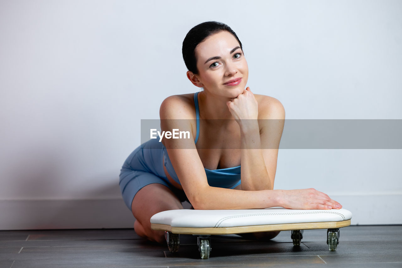 Portrait of smiling woman while sitting at gym