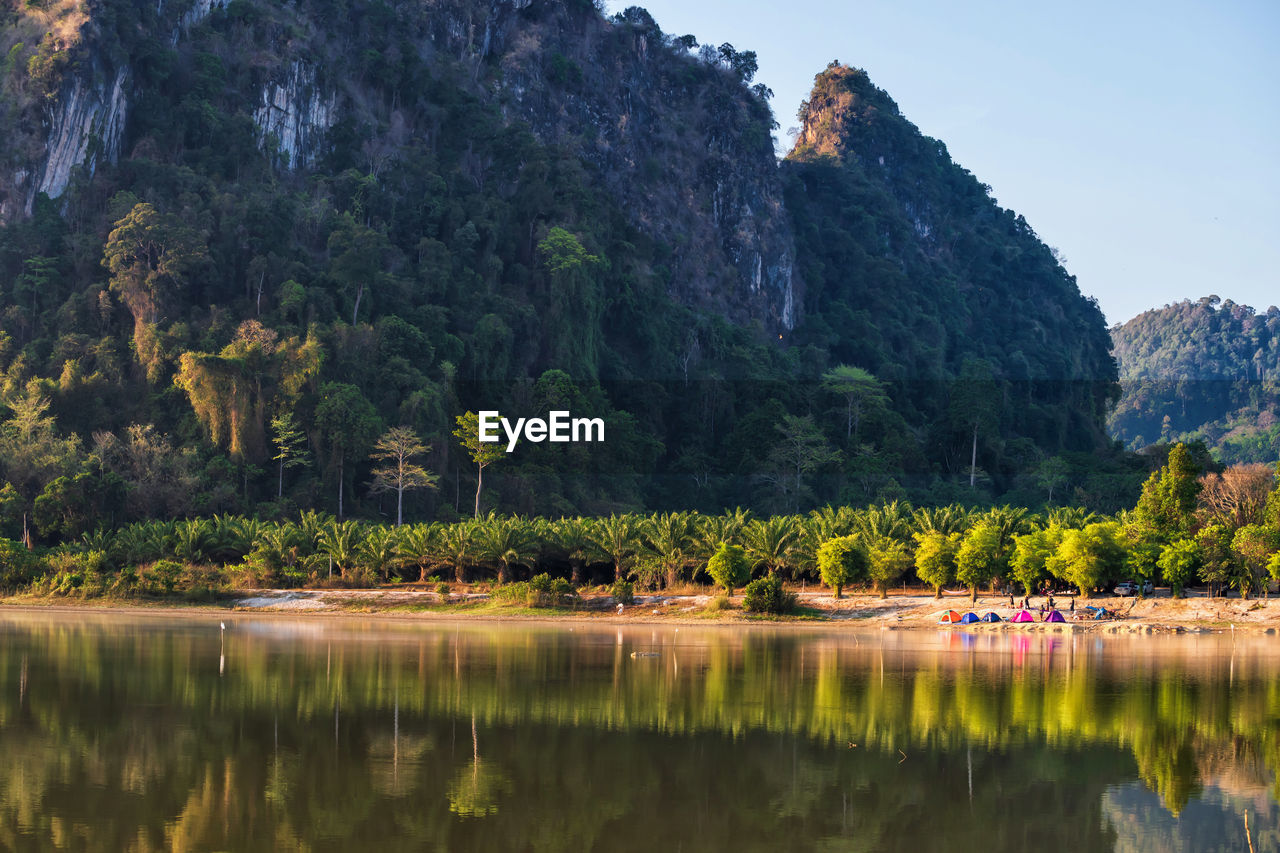 Camping at lake shore of nong thale lake and karst mountain at sunrise, krabi, thailand