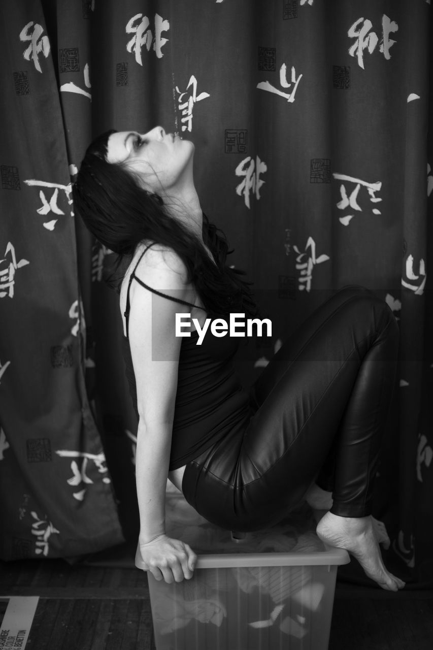 black, black and white, one person, adult, women, indoors, monochrome photography, monochrome, young adult, clothing, white, human leg, photo shoot, full length, lifestyles, female, limb, fashion, sitting, long hair