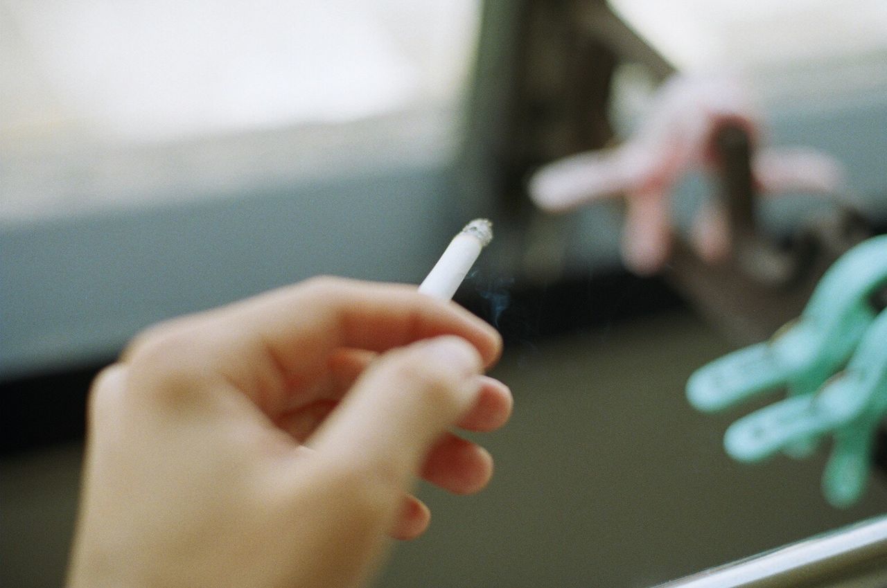 Close-up of hand holding cigarette