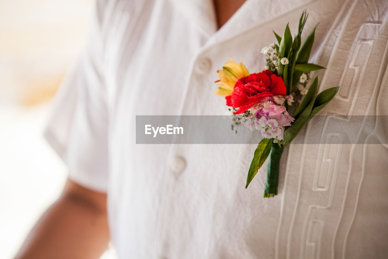 Close-up of flowers on man white shirt