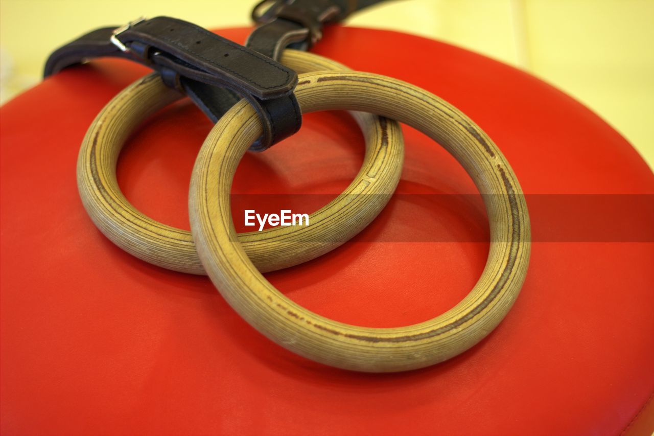 HIGH ANGLE VIEW OF ROPES ON TABLE AGAINST RED BACKGROUND