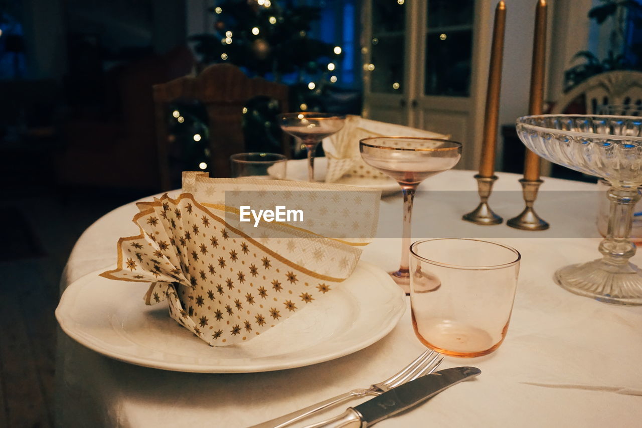 High angle view of napkin in plate with wineglasses on table