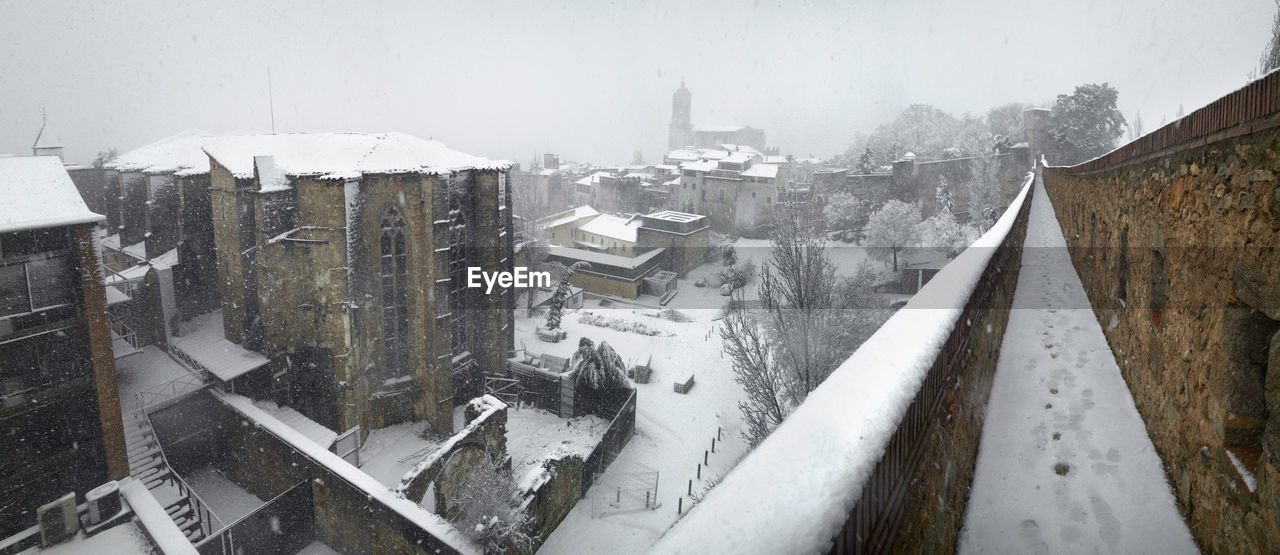 HIGH ANGLE VIEW OF SNOW COVERED CITY BUILDINGS